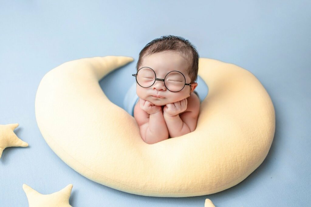 Bebé con lentes en almohada de luna