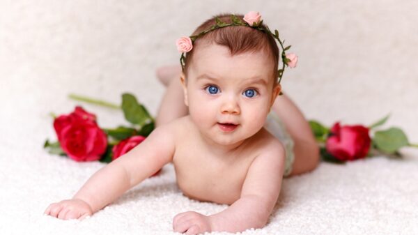 Bebé con corona de flores con rosas rojas