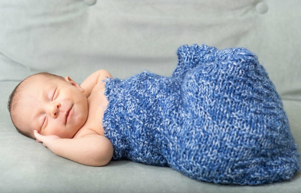 Bebé dormido con sábana azul