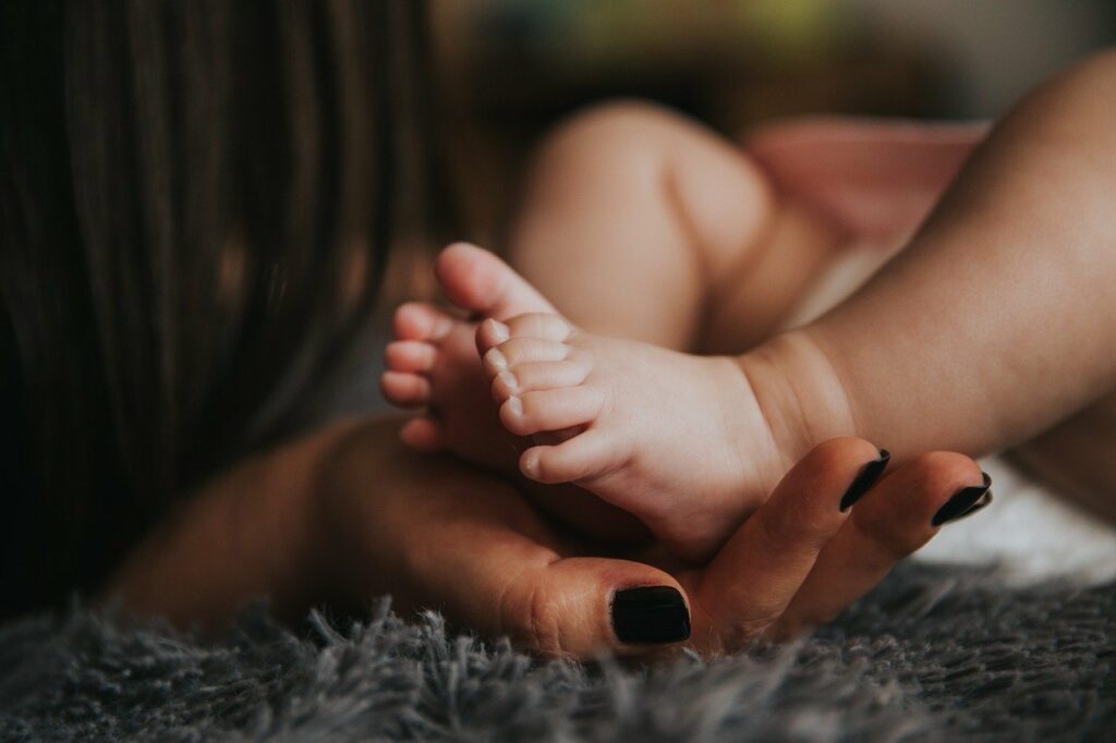 Mamá acariciando los pies de su bebé