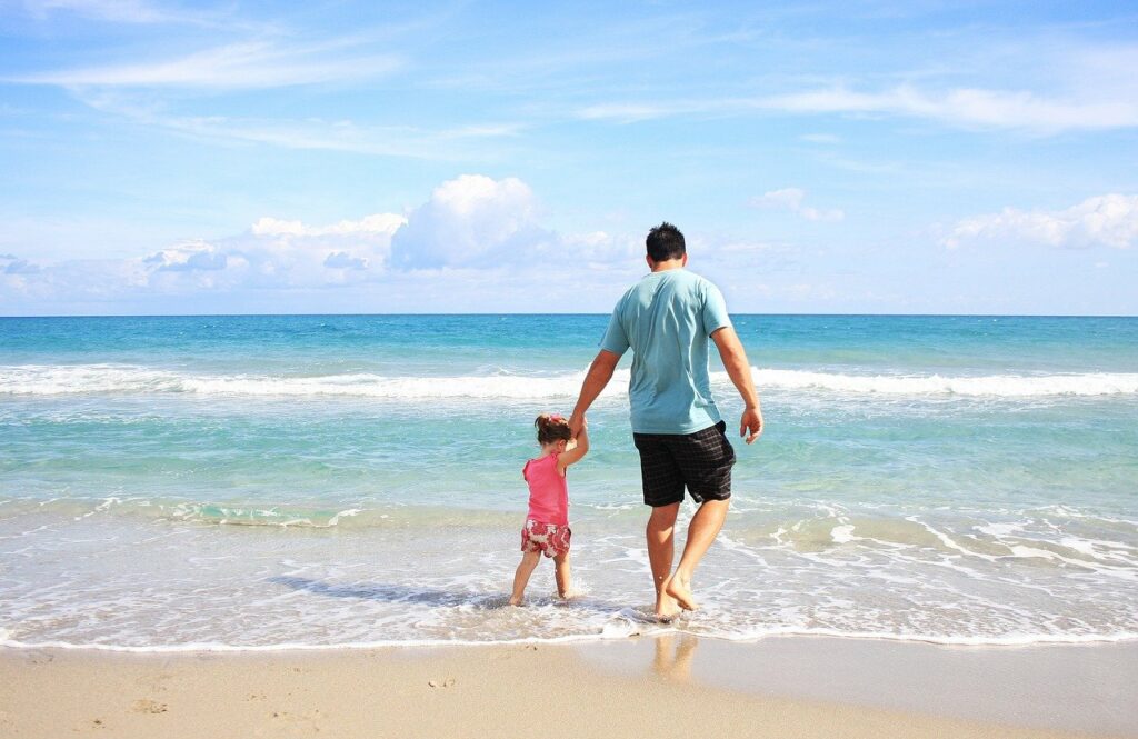 Papá con hija en la playa en semana santa 2022